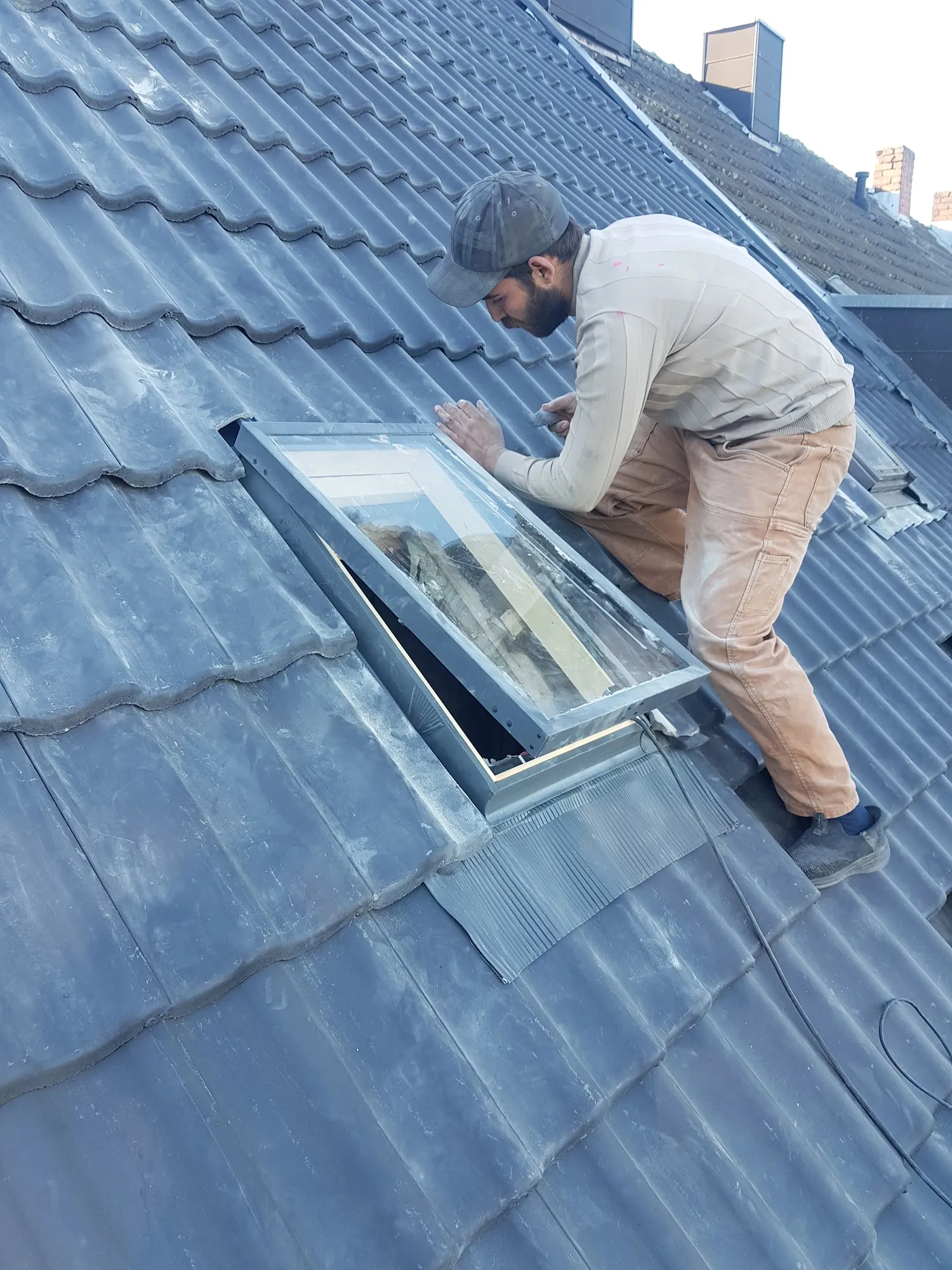 Dachdecker beim Einbau eines Dachfensters auf einem Ziegeldach